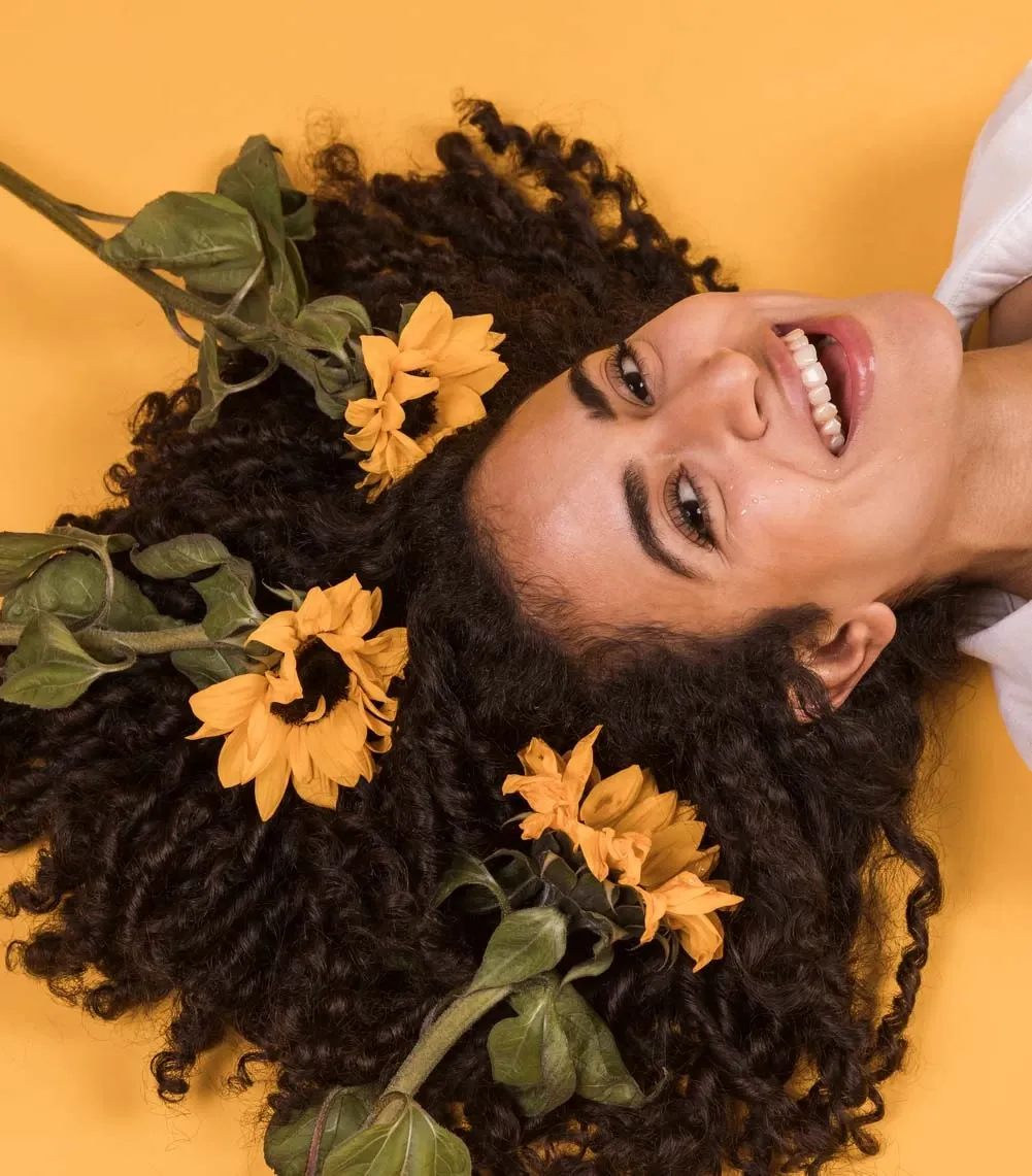 Mulher sorridente com cabelo cacheado e saudável