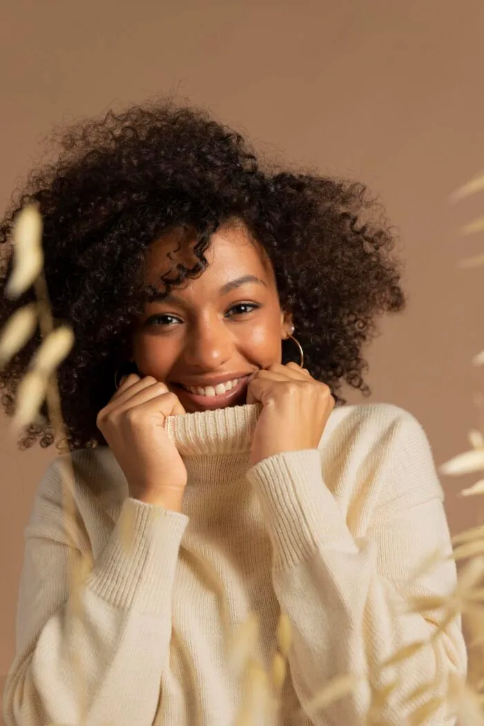 Mulher sorridente com cabelo cacheado